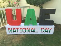 a sign that says usa national day in front of a fence with flowers and bushes