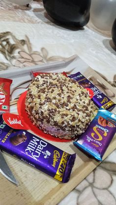 there is a cake on the table with chocolates and candy bars next to it