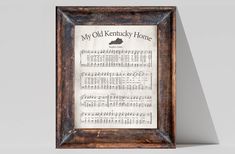 the old kentucky home sheet music is framed in a wooden frame on a white wall