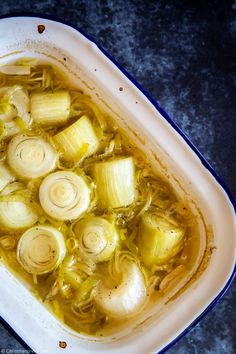 a bowl filled with soup and onions on top of a table