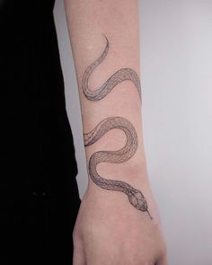 a woman's arm with a snake tattoo on it