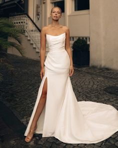 a woman in a white wedding dress posing for the camera