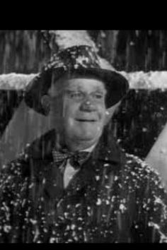 a man wearing a hat and bow tie in the rain