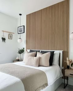 a bedroom with a bed, nightstand and wooden slatted headboard on the wall