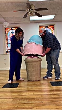 two people standing around a giant ice cream cone