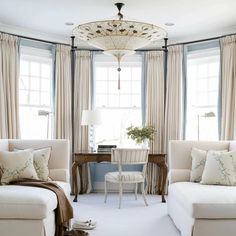 a living room filled with white furniture and windows