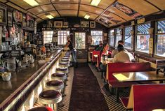 people sitting at tables in a restaurant with lots of pictures on the walls and ceiling