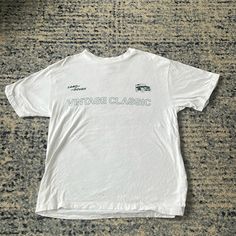 Never Worn Vintage White T-shirt With Text Print, Classic Logo Print Tops For Spring, Classic Streetwear Tops For Spring, Classic Spring Streetwear Tops, Classic Spring Tops With Letter Print, Classic Tops For Spring Streetwear, Classic Crew Neck Shirt With Graphic Print, Classic White Streetwear Shirt, Vintage White Tops With Letter Print