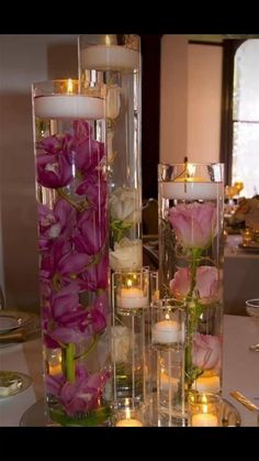 flowers and candles are arranged in glass vases