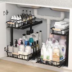 two black baskets filled with cleaning products under a sink