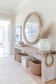 a white vase sitting on top of a wooden shelf next to baskets and a mirror