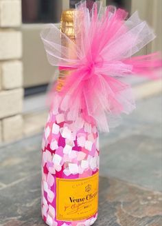 a bottle filled with pink and white candies sitting on top of a stone floor