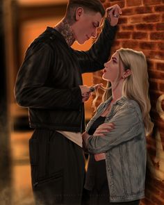 a man and woman standing next to each other near a brick wall with writing on it