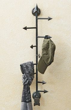 a coat rack with hats and gloves hanging on it's sides, next to a wall