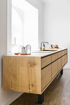 a kitchen with wooden cabinets and white walls