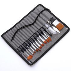 an assortment of paintbrushes in a case on a white surface with black handles