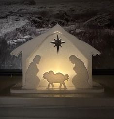 a lighted nativity scene with two men and a baby jesus in the manger