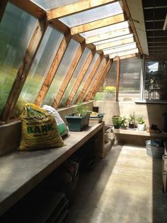 the inside of a building with lots of windows and plants in pots on the bench