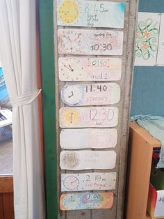 a wooden sign with numbers and times on it next to a window in a room