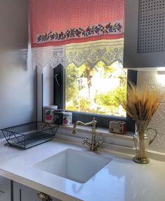 a kitchen sink sitting under a window next to a faucet