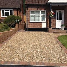 a gravel driveway in front of a brick house