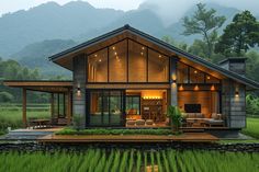 a small house in the middle of a lush green field with mountains in the background