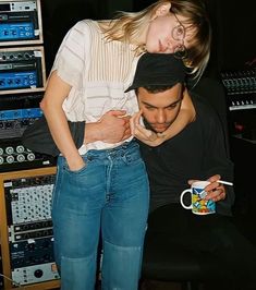 a man holding a woman in front of sound equipment