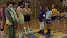 a group of young men standing on top of a basketball court next to each other