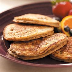 some pancakes are on a plate with fruit