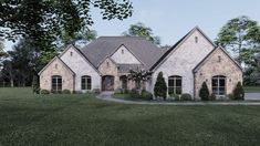 a large brick house in the middle of a grassy area with trees and bushes around it