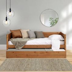 a bed sitting on top of a wooden floor next to a white rug and two hanging lights