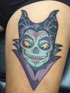 a woman's thigh with a tattoo on it that has a skull and bat