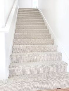 the stairs are lined with white herringbone carpet