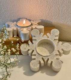 a snowflake candle holder next to some candles