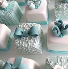 there are many square cakes decorated with blue ribbons and bowknots on them