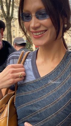 a woman is smiling while holding onto her purse