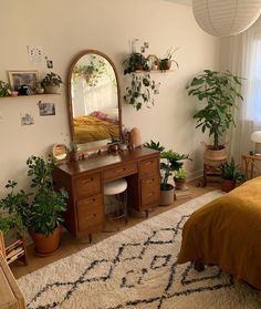 a bedroom with a bed, mirror and plants on the wall next to an area rug