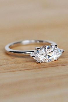 a diamond ring sitting on top of a wooden table