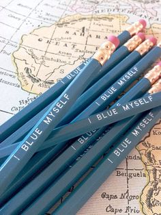 four blue pencils sitting on top of a map with the words i blue west written on them