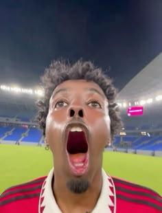 a man with his mouth open in front of a stadium