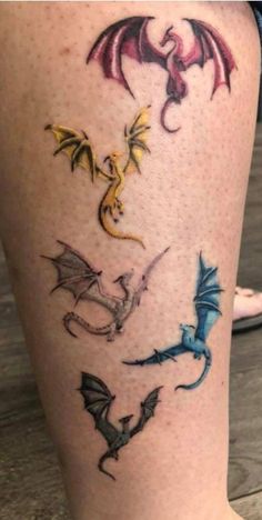 a woman's legs with different colored tattoos on her leg and the words dragon written in