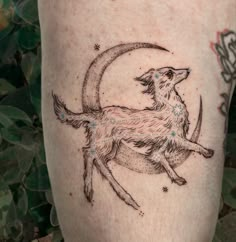 a tattoo on the leg of a person with a dog sitting on it's back