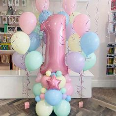 a large number one balloon arrangement in a store with pastel blue, pink and white balloons