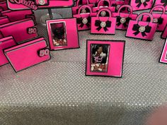 there are many pink and black bags on the floor with pictures in them that look like purses