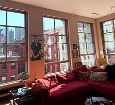 a living room filled with lots of windows next to a red couch and coffee table