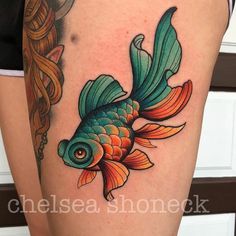 a woman's thigh with a goldfish tattoo on it