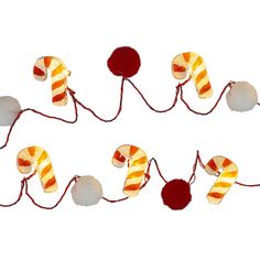 a string of candy canes with pom - poms attached to them on a white background