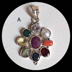 Genuine 925 Sterling Silver Navratan Pandent  Gemstone - Ruby , Emerald , Blue Sapphire, Yellow Sapphire, Hessonite, Cats Eye, Coral, Pearl, Cubic Zircona.  Stones setted - 9 pieces Quantity - 1 PC. No. - A.  No. - B. No. - C.  QTY - 1 piece in this listing. The navratna or nine gems influencing the nine planets are:  Ruby  =  Sun ,  Pearl = Moon, Red Coral = Mars, Emerald = Mercury,  Yellow Sapphire = Jupiter, zircon = Venus, Blue Sapphire = Saturn,  Hessonite = Rahu , Cat''s Eye = Ketu . Spiritual Oval Stone Setting Jewelry, Spiritual Round Stone Setting Jewelry, Fusion Style Birthstone Pendant Jewelry, Silver Jewelry With Round Gemstone, Oval Multi-stone Gemstones For Gift, Silver Jewelry With Natural Round Stones, Silver Fusion Jewelry With Stones, Oval Multi-stone Gemstones As A Gift, Multicolor Stone Setting Jewelry Gift