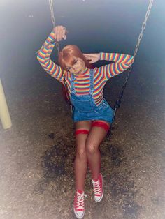 a woman sitting on a swing with her hands behind her back and legs bent up