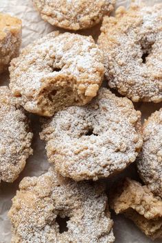 powdered sugar covered donuts sitting on top of a piece of paper